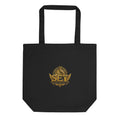 Black organic cotton tote with a centered gold SET crest on the front