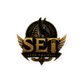 Gold-and-black SET Anubis crest kiss-cut vinyl sticker — 4 by 4 inch product mockup.