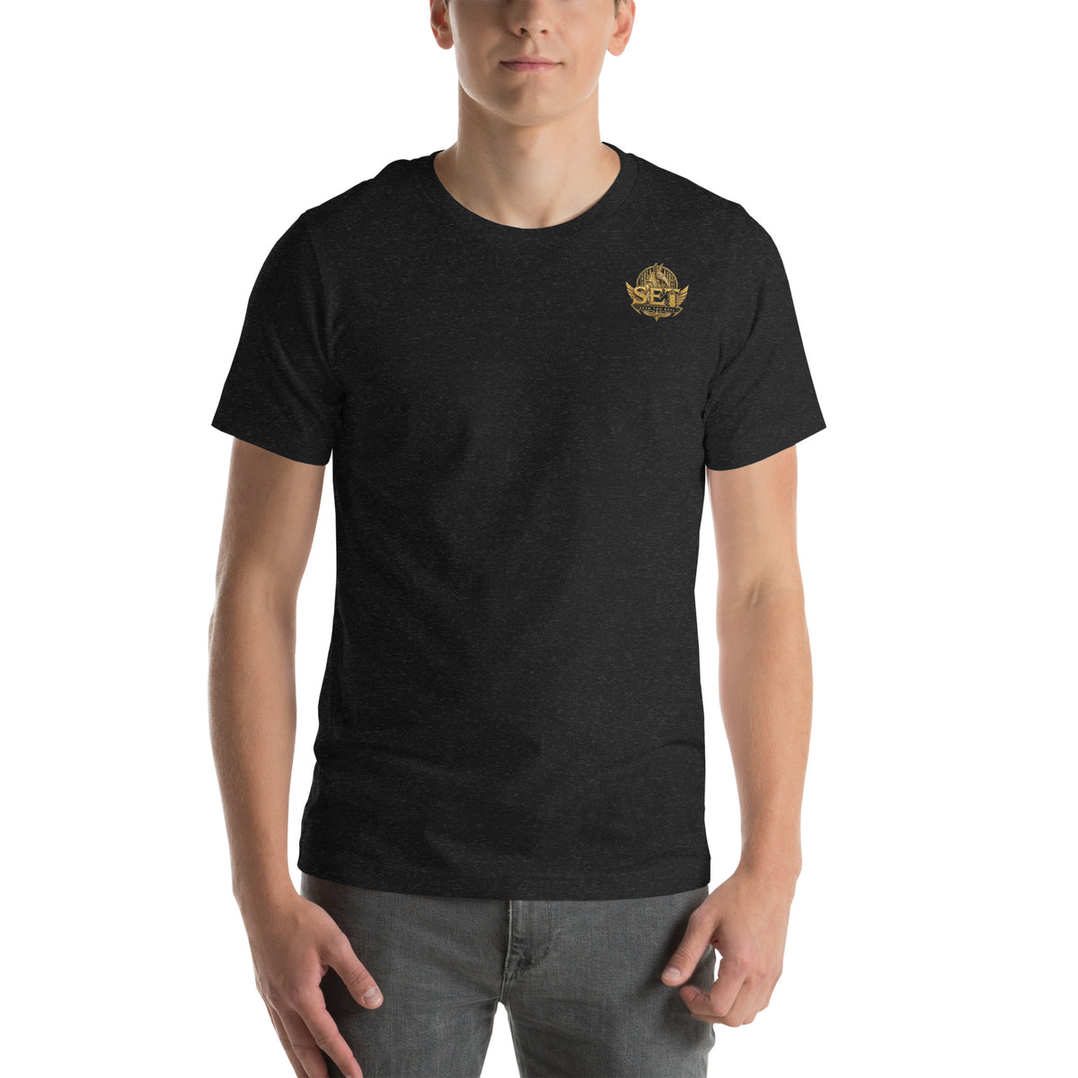 Black heather unisex staple T-shirt with the gold-tone SET Anubis crest on the wearer’s left chest — front view.